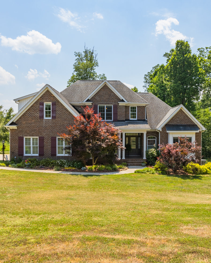 Front porch of a brick home listed by Piedmont Triad Realty